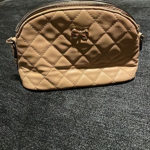 Tan bag with small gold bow in front
